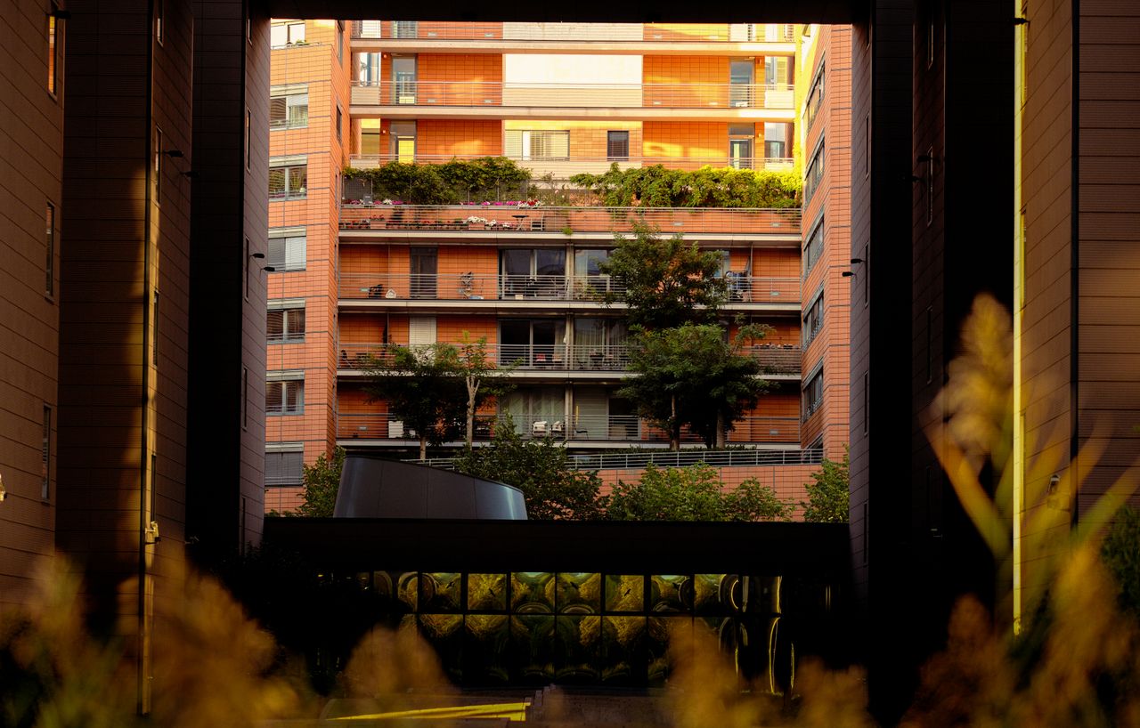 Urban apartment complex with modern design and greenery at sunset.